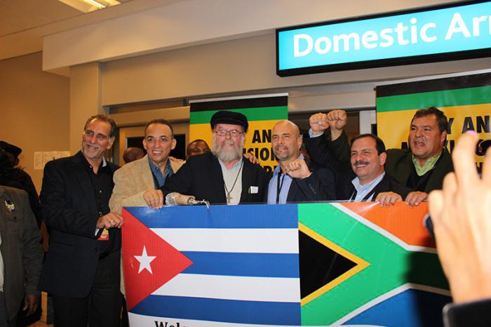 Le père sud-africain Michael Lapsley (avec une casquette) et les cinq antiterroristes cubains à leur arrivée à Cape Town, capitale d’Afrique du Sud.