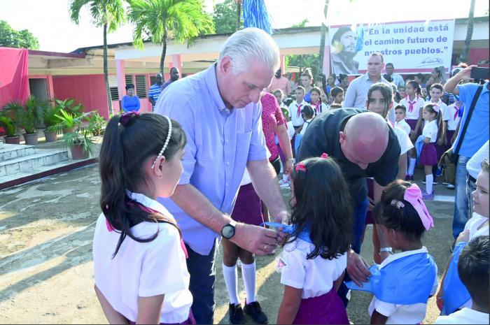 Le président cubain s'est joint à la belle tradition qui consiste à remettre le foulard bleu aux jeunes élèves de CP. 